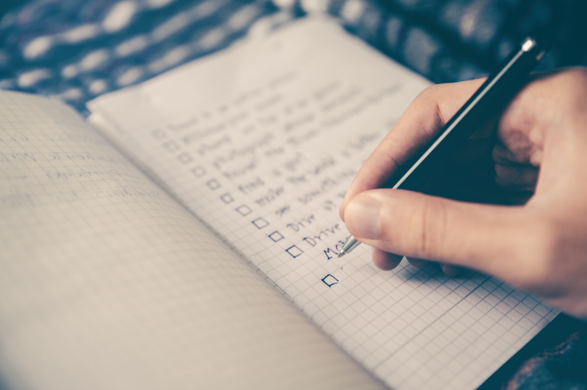 Person crossing off paid debt from a list feeling motivated by progress