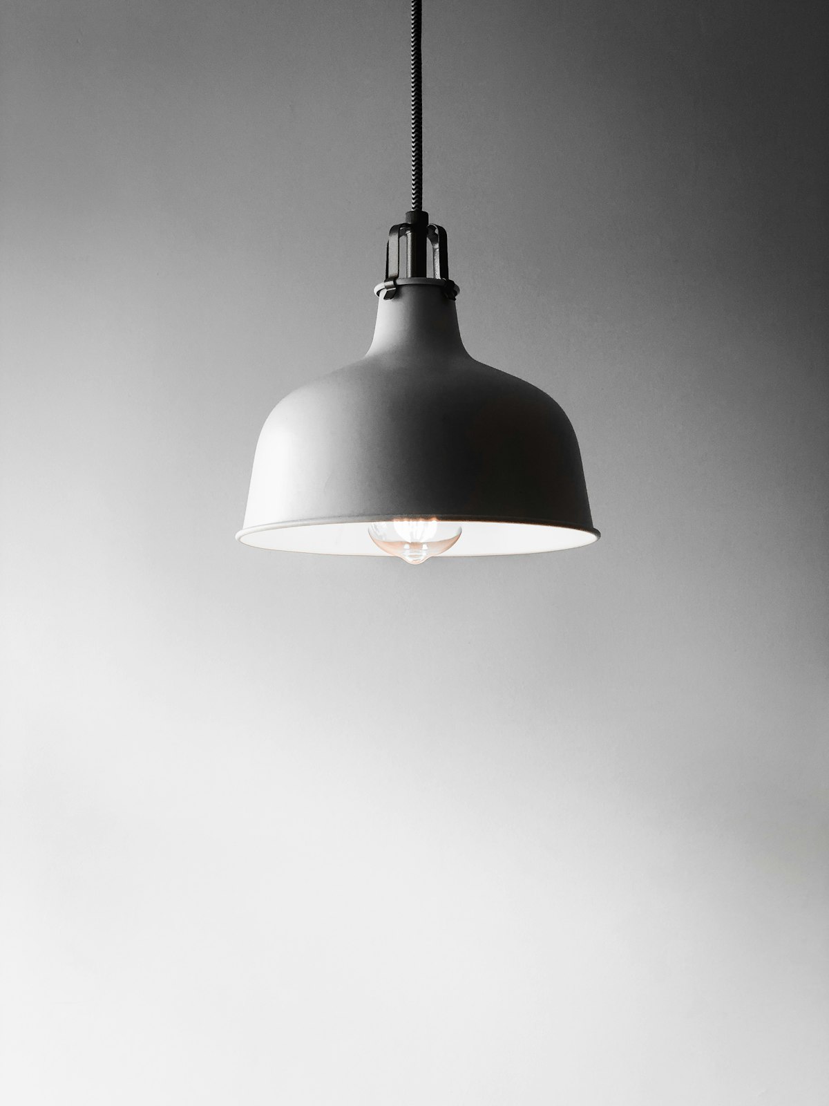 Illuminated light bulb hanging — energy costs at home